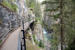 01 Walking Up Boardwalk Towards Lower Falls In Johnston Canyon In Summer.jpg